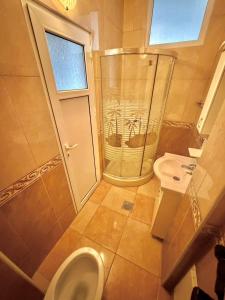 a bathroom with a shower and a toilet and a sink at Vala Rooms in Struga