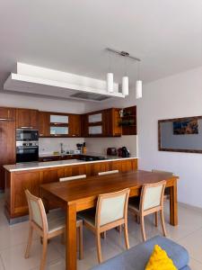 a kitchen with a wooden table and chairs at Marsaxlokk Harbour View Apartment in Marsaxlokk