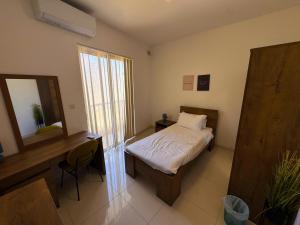 a bedroom with a bed and a desk and a mirror at Marsaxlokk Harbour View Apartment in Marsaxlokk