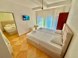 a bedroom with a large white bed and a mirror at Vala Rooms in Struga +20 photos