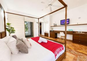 a bedroom with a large bed with a red blanket at Solanza Hotel Hacienda in Cancún