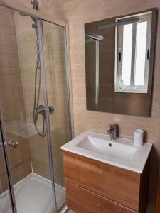 a bathroom with a sink and a shower with a mirror at Marsaxlokk Harbour View Apartment in Marsaxlokk +24 photos