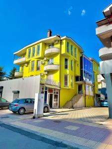 a yellow building with cars parked in front of it at Vala Rooms in Struga