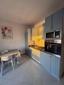 a kitchen with blue cabinets and a table and a dining room at Tramonto di Calabria in Pizzo