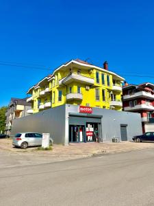 a yellow building with a car parked in front of it at Vala Rooms in Struga