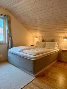 a large bed in a room with a wooden ceiling at Dalen Bed & Breakfast in Dalen