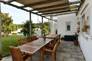 a wooden table and chairs on a patio at Casa do Sol Wellness Villa in Óbidos