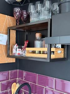 a shelf in a kitchen with purple tiles at Studio apartman Gradna in Samobor