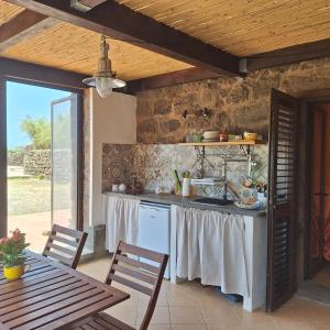 a kitchen with a table and a counter top at Dammuso Surya Il cappero monolocale in Pantelleria
