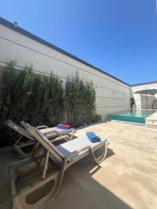 a pair of lounge chairs sitting next to a swimming pool at Villa 4 chambres avec piscine in Tangier
