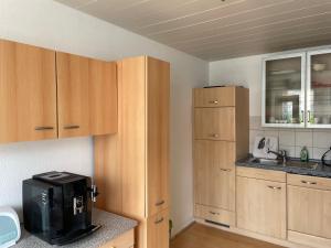 a kitchen with wooden cabinets and a microwave at Ferienwohnung Kannemann in Herzberg am Harz