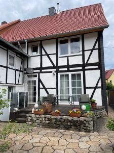 a white and black house with a patio at Ferienwohnung Kannemann in Herzberg am Harz +4 photos