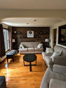 a living room with two couches and a table at Finnegan's Cottage in Placentia