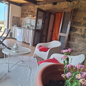 a living room with a couch and a table at Dammuso Surya Il cappero monolocale in Pantelleria +17 photos
