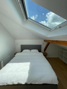 a bedroom with a bed with a large window at Appartement Wonder 2 au centre de Couvet in Couvet