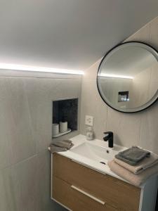 a bathroom with a sink and a mirror at Appartement Wonder 2 au centre de Couvet in Couvet