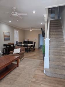 a living room with a staircase and a couch and a table at Shore Getaway 2 in Atlantic City
