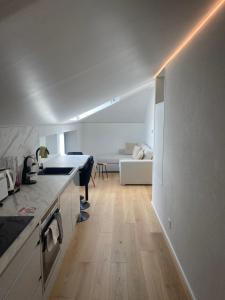 a room with a kitchen and a living room with a couch at Appartement Wonder 2 au centre de Couvet in Couvet