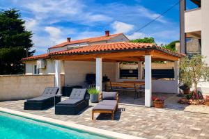 a house with a pavilion and a swimming pool at Small stone house in Ližnjan