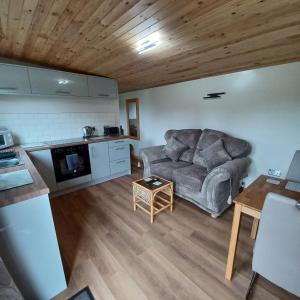a living room with a couch and a table at Dunroaming Cabin in Pendine +8 photos
