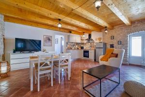 a kitchen and living room with a table and chairs at Small stone house in Ližnjan