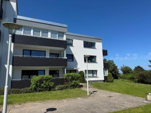a white apartment building with a driveway at gemütliche Ferienwohnung Anker in Schilksee am Strand in Kiel