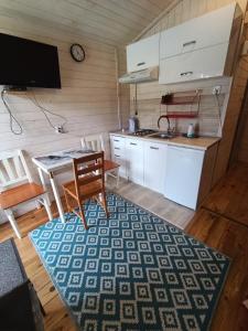 a kitchen with a table and a dining room at Domki Helena Okuninka in Okuninka