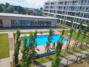 an overhead view of a swimming pool in front of a building at Apartament rodzinny 47, 150 m od plaży, basen, plac zabaw, darmowy parking! in Sianozety