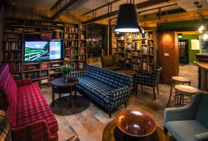 a library with a couch and a tv and books at Akademia Kuraszków in Kuraszków