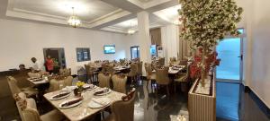a dining room with tables and chairs and flowers at Ridge Condos Hotel - Phase Three in Kumasi