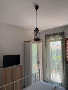 a bedroom with a bed and a tv and a window at Apartmani Primorski kutak in Jadranovo