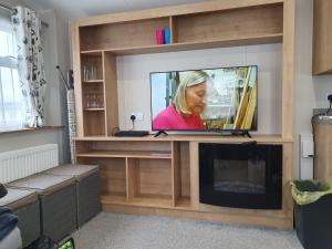 a television in a wooden entertainment center at Kazamar in East Mersea