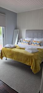 a bedroom with a large bed with a yellow blanket at Chez Tronqueira 43 in Faja Grande