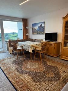 a living room with a table and chairs and a television at FeWo Luisa in Neureichenau