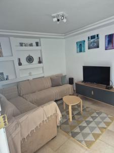 a living room with a couch and a table at L'ancienne menuiserie in Tabarka