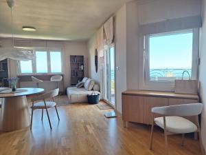 a living room with a couch and a table and chairs at Apartment Sunrise in Kunjići