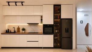 a kitchen with white cabinets and a black refrigerator at Apartment by Bar in Bar