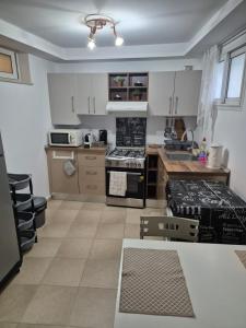 a kitchen with white cabinets and a stove top oven at L'ancienne menuiserie in Tabarka