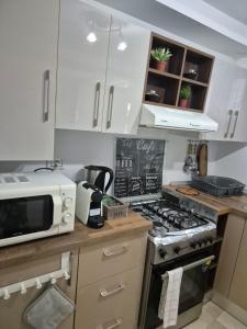 a kitchen with a stove and a microwave at L'ancienne menuiserie in Tabarka +2 photos