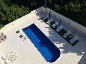 an overhead view of a swimming pool with lawn chairs at Apartment Sunrise in Kunjići