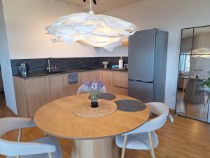 a kitchen with a table with chairs and a refrigerator at Apartment Sunrise in Kunjići