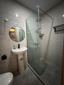 a bathroom with a glass shower and a sink at Modern 2 BR apartment in Lekki