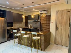 a kitchen with a bar with stools in it at Modern 2 BR apartment in Lekki +10 photos