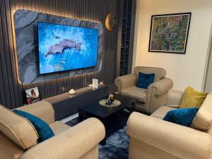 a living room with two chairs and a tv at Modern 2 BR apartment in Lekki