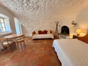 a bedroom with a bed and a table and a couch at La Petite Bergerie in Éze