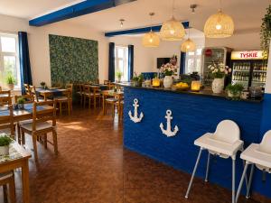 a restaurant with a blue counter and tables and chairs at Zajazd Nadmorski in Stegna