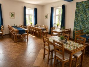 a restaurant with wooden tables and chairs and windows at Zajazd Nadmorski in Stegna +23 photos