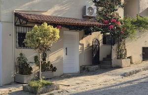 a white house with a white door and a tree at L'ancienne menuiserie in Tabarka
