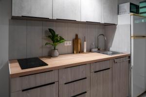 a kitchen with a wooden counter top and a sink at Kay Canou - Vue jardin tropical - Calme & nature in Le Robert