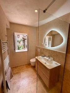 a bathroom with a sink and a toilet and a mirror at La Petite Bergerie in Éze